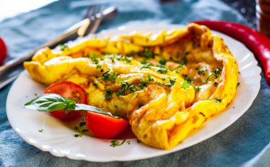 ahşap masa üzerinde beyaz bir tabak içinde omlet