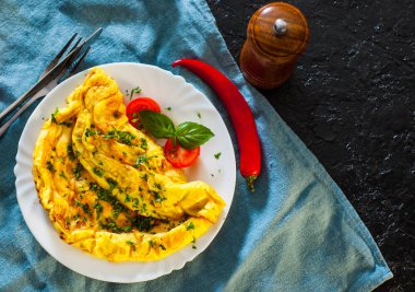 ahşap masa üzerinde beyaz bir tabak içinde omlet