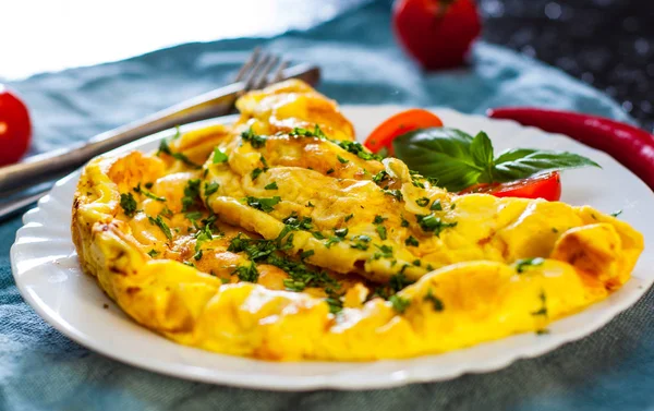 ahşap masa üzerinde beyaz bir tabak içinde omlet