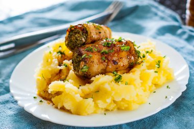 tavuk ve domuz eti masada beyaz tabak patates püresi ile Kavrulmuş dana eti rulo dolması