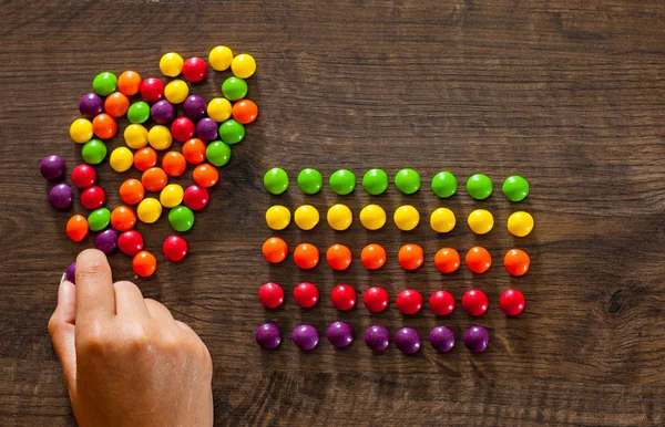 Vrouw Hand Verzamelt Zelfs Rij Van Kleurrijke Snoepjes Een Houten — Stockfoto