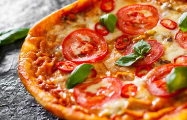 Pizza Mozzarella peyniri, jambon, domates, biber, baharat ve taze fesleğen. İtalyan pizza.on siyah arka plan. kopya alanı ile. üstten görünüm