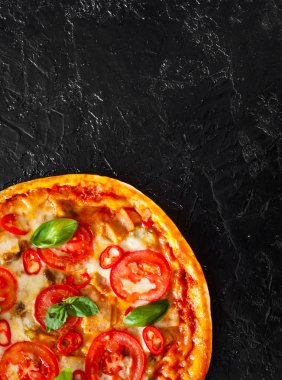 Pizza Mozzarella peyniri, jambon, domates, biber, baharat ve taze fesleğen. İtalyan pizza.on siyah arka plan. kopya alanı ile. üstten görünüm