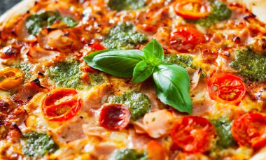 Pizza Mozzarella peyniri, jambon, domates, biber, baharat ve taze fesleğen pesto sos. İtalyan pizza.on siyah arka plan.