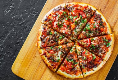 dilimlenmiş Pizza Mozzarella peyniri, mantar, domates, biber, baharat ve taze fesleğen. İtalyan pizza. siyah arka plan üzerine. kopya alanı ile. üstten görünüm