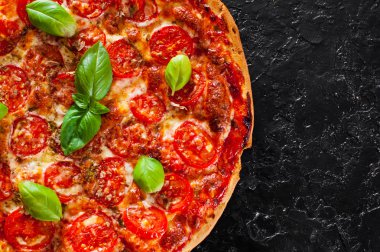 Pizza Mozzarella peyniri, domates, biber, baharat ve taze fesleğen. İtalyan pizza. Pizza Margherita veya Margarita. siyah arka plan üzerine. kopya alanı ile. üstten görünüm