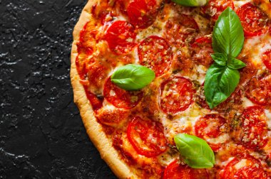 Pizza Mozzarella peyniri, domates, biber, baharat ve taze fesleğen. İtalyan pizza. Pizza Margherita veya Margarita. siyah arka plan üzerine. kopya alanı ile. üstten görünüm