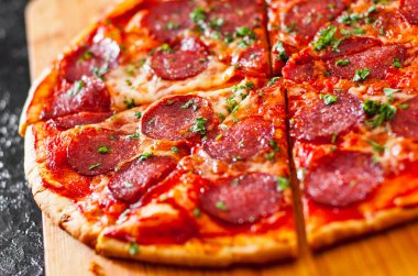 dilimlenmiş Pepperoni Pizza Mozzarella peyniri, salam, domates, biber, baharat ve taze fesleğen. İtalyan pizza