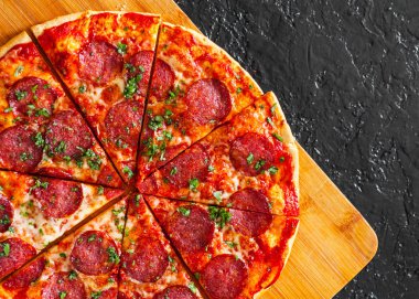 dilimlenmiş Pepperoni Pizza Mozzarella peyniri, salam, domates, biber, baharat ve taze fesleğen. İtalyan pizza