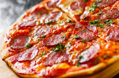 dilimlenmiş Pepperoni Pizza Mozzarella peyniri, salam, domates, biber, baharat ve taze fesleğen. İtalyan pizza
