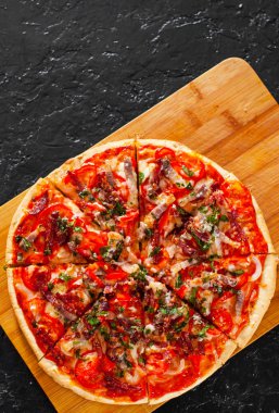 dilimlenmiş Pizza Mozzarella peyniri, jambon, domates, salam, biber, pastırma, biber, baharat ve taze fesleğen. İtalyan pizza