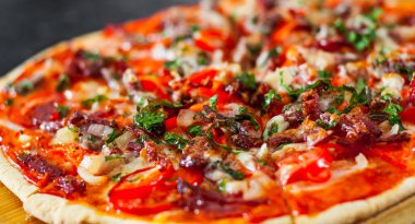 dilimlenmiş Pizza Mozzarella peyniri, jambon, domates, salam, biber, pastırma, biber, baharat ve taze fesleğen. İtalyan pizza