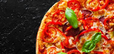 Pizza Mozzarella peyniri, jambon, domates, salam, biber, biber baharat ve taze fesleğen. İtalyan pizza.on siyah arka plan