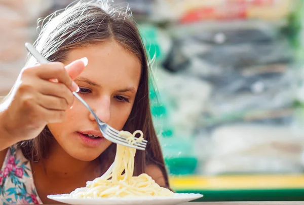 代の女の子を食べるスパゲティのパスタの肖像画 — ストック写真