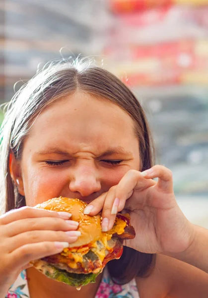 代の少女の肖像画は ハンバーガーを食べる ファーストフードを食べるしようとしている女の子 — ストック写真