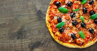 Pizza Mozzarella peyniri, salam, biber, biber, domates, zeytin, baharat ve taze fesleğen. İtalyan pizza ahşap arka plan üzerinde. kopya alanı ile. üstten görünüm