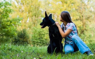 parkta açık bir çoban köpeği ile genç Genç kız