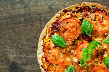 Pizza Mozzarella peyniri, domates, biber, baharat ve taze fesleğen. İtalyan pizza. Pizza Margherita veya Margarita. ahşap arka plan üzerinde. kopya alanı ile. üstten görünüm