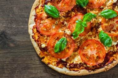 Pizza Mozzarella peyniri, domates, biber, baharat ve taze fesleğen. İtalyan pizza. Pizza Margherita veya Margarita. ahşap arka plan üzerinde. kopya alanı ile. üstten görünüm