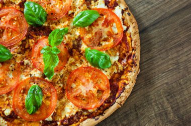 Pizza Mozzarella peyniri, domates, biber, baharat ve taze fesleğen. İtalyan pizza. Pizza Margherita veya Margarita. ahşap arka plan üzerinde. kopya alanı ile. üstten görünüm