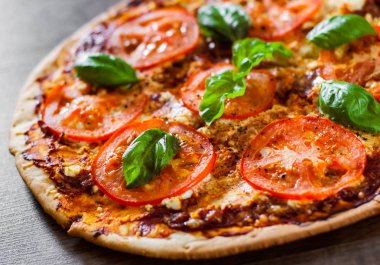 Pizza Mozzarella peyniri, domates, biber, baharat ve taze fesleğen. İtalyan pizza. Pizza Margherita veya Margarita. ahşap arka plan üzerinde