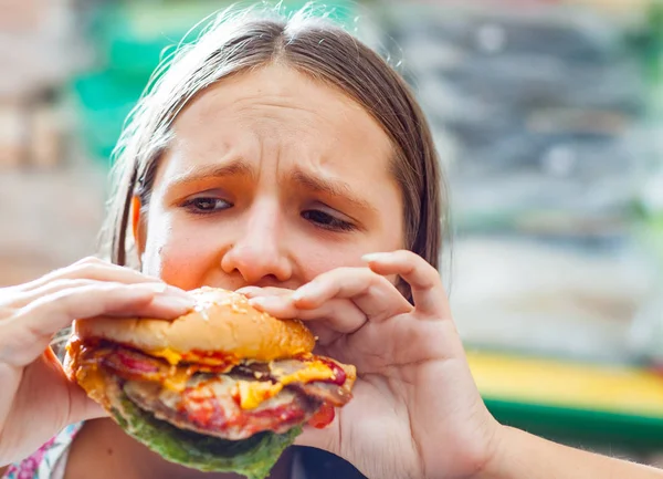 代の少女の肖像画は ハンバーガーを食べる ファーストフードを食べるしようとしている女の子 — ストック写真