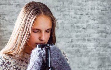 uzun saçlı bir kaba tutan genç Genç esmer kız portresi gri duvar arka plan üzerinde eller