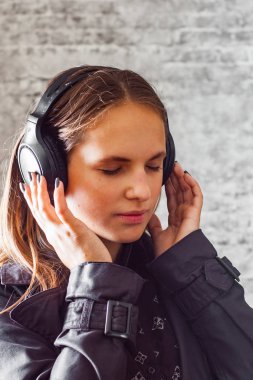 uzun saç gri duvar arka plan kulaklıktan dinleme müzik ile genç Genç esmer kız portresi