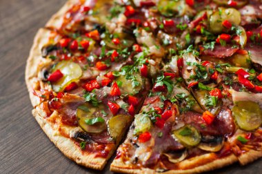 Pizza dilimlenmiş Mozzarella peyniri, mantar, salam, pastırma, domates, biber, baharat ve taze fesleğen. Ahşap arka plan üzerinde İtalyan pizza.