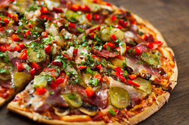 Pizza dilimlenmiş Mozzarella peyniri, mantar, salam, pastırma, domates, biber, baharat ve taze fesleğen. Ahşap arka plan üzerinde İtalyan pizza.