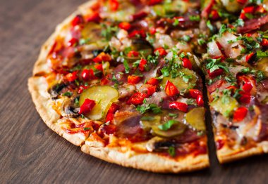 Pizza dilimlenmiş Mozzarella peyniri, mantar, salam, pastırma, domates, biber, baharat ve taze fesleğen. Ahşap arka plan üzerinde İtalyan pizza.