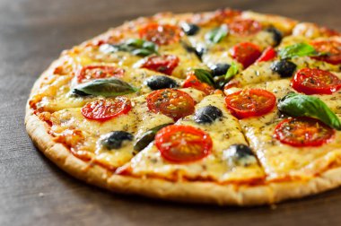 dilimlenmiş Pizza Margherita veya Mozzarella peyniri, domates, zeytin ile Margarita. Ahşap arka plan üzerinde İtalyan pizza