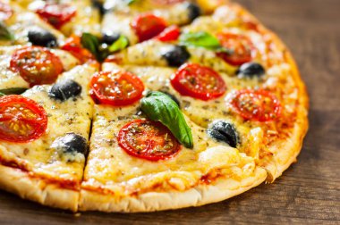 dilimlenmiş Pizza Margherita veya Mozzarella peyniri, domates, zeytin ile Margarita. Ahşap arka plan üzerinde İtalyan pizza