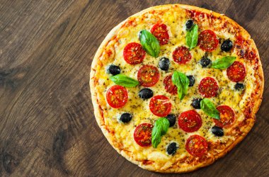 Pizza Margherita veya Mozzarella peyniri, domates, zeytin ile Margarita. Ahşap arka plan üzerinde İtalyan pizza