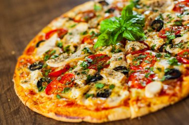 Tavuk eti, Mozzarella peyniri, domates, zeytin dilimlenmiş Pizza. Ahşap arka plan üzerinde İtalyan pizza