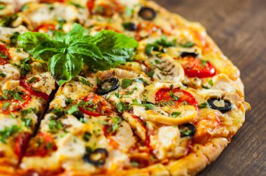 Tavuk eti, Mozzarella peyniri, domates, zeytin dilimlenmiş Pizza. Ahşap arka plan üzerinde İtalyan pizza