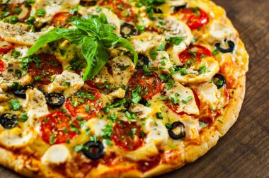 Tavuk eti, Mozzarella peyniri, domates, zeytin pizza. Ahşap arka plan üzerinde İtalyan pizza