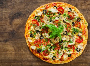 Tavuk eti, Mozzarella peyniri, domates, zeytin pizza. Ahşap arka plan üzerinde İtalyan pizza