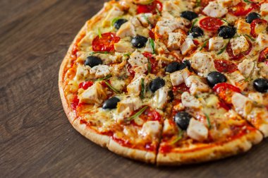 Tavuk eti, Mozzarella peyniri, domates, zeytin dilimlenmiş Pizza. Ahşap arka plan üzerinde İtalyan pizza