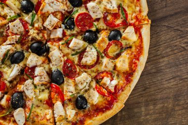 Tavuk eti, Mozzarella peyniri, domates, zeytin dilimlenmiş Pizza. Ahşap arka plan üzerinde İtalyan pizza