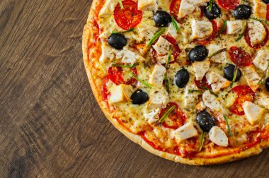 Tavuk eti, Mozzarella peyniri, domates, zeytin pizza. Ahşap arka plan üzerinde İtalyan pizza