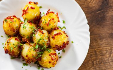 Ahşap masa arka plan üzerinde beyaz tabak içinde taze patates böreği