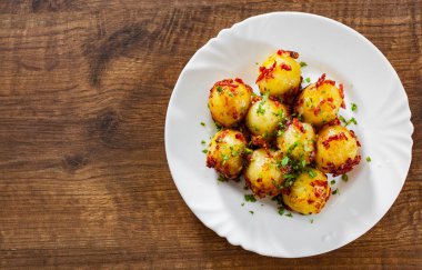 Ahşap masa arka plan üzerinde beyaz tabak içinde taze patates böreği