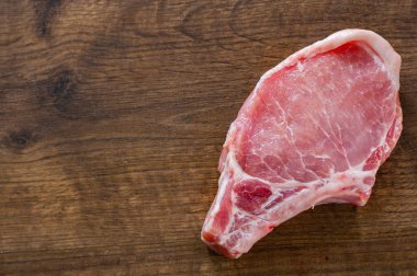 Çiğ domuz Loin kopya alanı ahşap masa zemin üzerine et pirzola. üstten görünüm