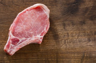 Çiğ domuz Loin kopya alanı ahşap masa zemin üzerine et pirzola. üstten görünüm