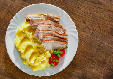 Et dilimleri ahşap masa arka plan üzerinde beyaz tabak patates püresi ile