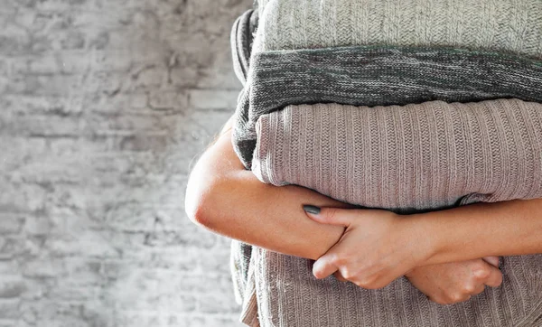 Frau Hält Den Händen Stapel Von Gemütlichen Strickpullovern Auf Grauem — Stockfoto