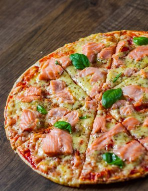 Pizza Mozzarella peyniri, somon balığı, domates sosu. Ahşap masa arka plan üzerinde İtalyan pizza