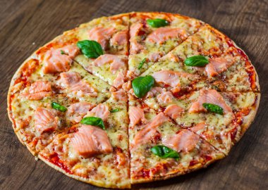 Pizza Mozzarella peyniri, somon balığı, domates sosu. Ahşap masa arka plan üzerinde İtalyan pizza