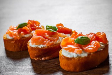 Ahşap masa arka plan üzerinde füme somon ve krem peynirli kanepeler